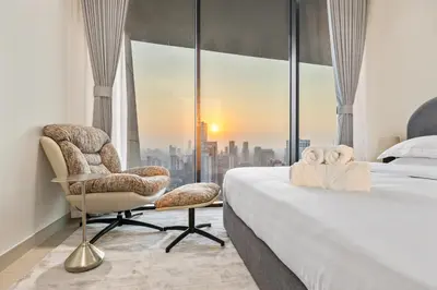 a bedroom with a bed and a chair and a window at Private Pool - Amazing 1BR Apartment in JVC in Dubai