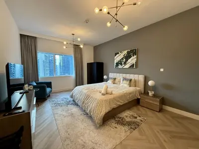 a bedroom with a bed and a living room at Casa Marina - great views & pool, fully equipped in Dubai