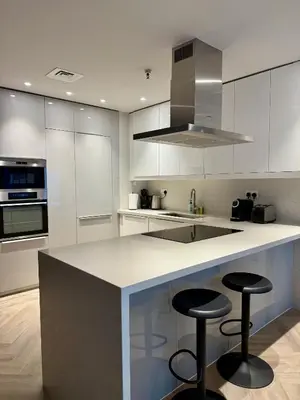 a kitchen with two bar stools and a counter top at Casa Marina - great views & pool, fully equipped in Dubai