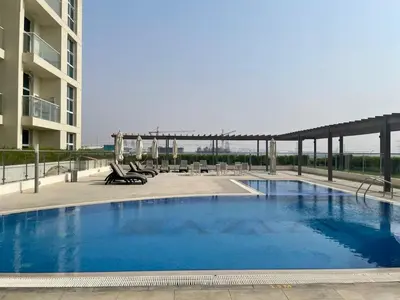 a large swimming pool next to a building at Studio near Marina - 15mins drive in Dubai