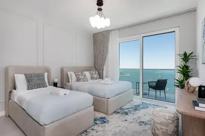 a bedroom with two beds and a view of the ocean at La Vie Apartments in Dubai