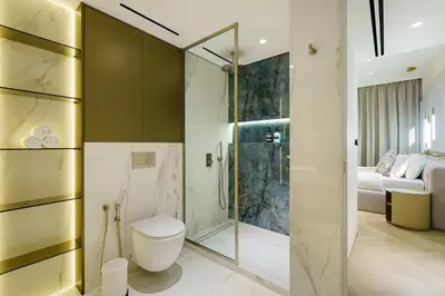 a bathroom with a toilet and a glass shower at Luxurious 2BR Breathtaking Huge Pool & Sea Views in Dubai