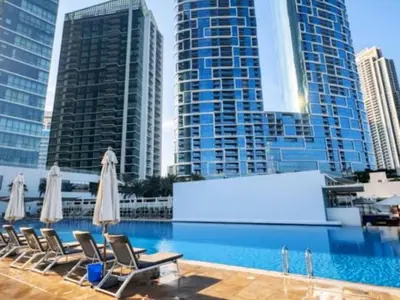 a pool with chairs and umbrellas and some buildings at Luxurious 2BR Breathtaking Huge Pool & Sea Views in Dubai