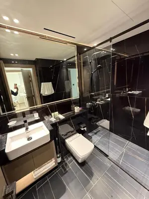 a bathroom with a sink and a toilet and a mirror at Luxury 1BR Apartment In Binghatti Corner, High Floor In JVC in Dubai