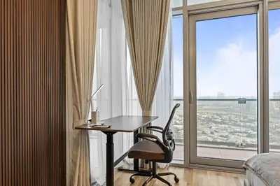 a bedroom with a desk and a chair in front of a window at YOUR STAY CORPORATE RESIDENCES DIFC Burj Daman in Dubai