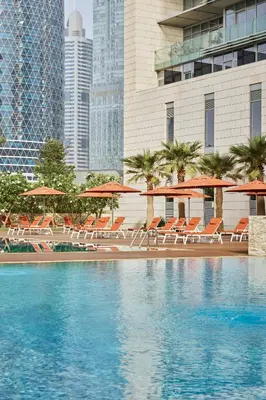 a pool with chairs and umbrellas in a city at YOUR STAY CORPORATE RESIDENCES DIFC Burj Daman in Dubai
