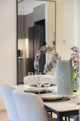 a dining room table with chairs and wine glasses at Luxury 2BR Downtown Dubai, Grande Signature with Stunning Burj Khalifa and Dubai Opera Views, steps to Dubai Mall by La Brisa in Dubai
