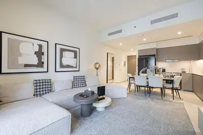 a living room with a couch and a kitchen at Luxury 2BR Downtown Dubai, Grande Signature with Stunning Burj Khalifa and Dubai Opera Views, steps to Dubai Mall by La Brisa in Dubai