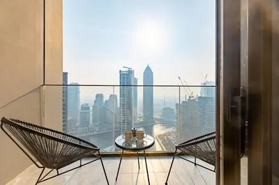 a balcony with a table and chairs and a view of a city at PENINSULA ONE 1BR by Design Studio in Dubai