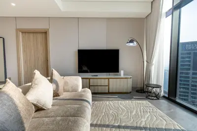 a living room with a couch and a flat screen tv at PENINSULA ONE 1BR by Design Studio in Dubai