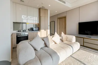 a large couch in a living room with a television at PENINSULA ONE 1BR by Design Studio in Dubai