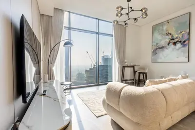 a living room with a couch and a large window at PENINSULA ONE 1BR by Design Studio in Dubai