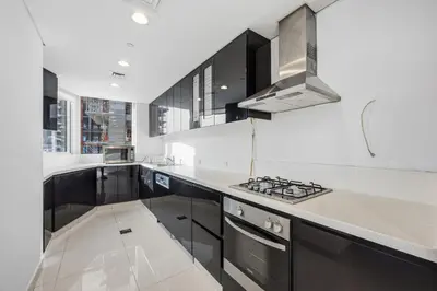 a kitchen with black cabinets and white counter tops at 3 Bedroom unit at DAMAC maison Canal Views in Dubai