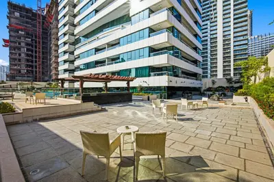 a patio with chairs and tables in front of a building at 3 Bedroom unit at DAMAC maison Canal Views in Dubai