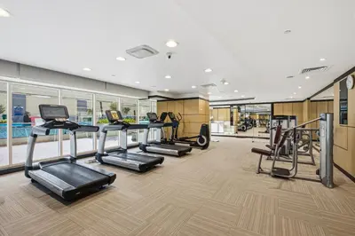 a gym with several treadmills and elliptical machines at 3 Bedroom unit at DAMAC maison Canal Views in Dubai
