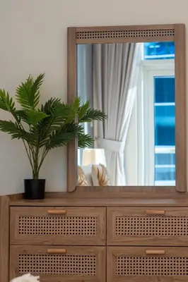 a mirror on top of a dresser with a plant on it at Nivis find- Bay square -1 BHK in Dubai