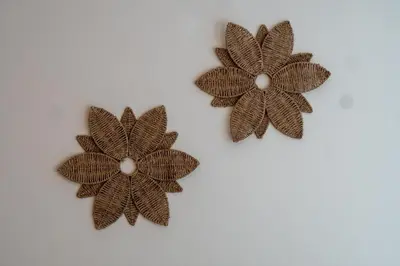 two brown metal flowers on a white wall at Nivis find- Bay square -1 BHK in Dubai