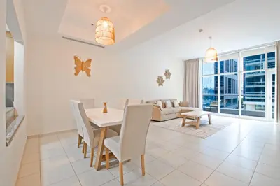 a dining room and living room with a table and chairs at Nivis find- Bay square -1 BHK in Dubai