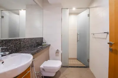 a bathroom with a toilet and a sink and a shower at Nivis find- Bay square -1 BHK in Dubai
