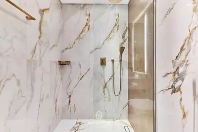 a white bathroom with a shower and a toilet at Luxury Elie Saab 3BR Villa in Jasmine Lane in Dubai