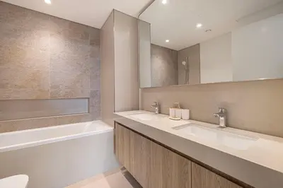 a bathroom with two sinks and a tub and a mirror at Modern Downtown Apartment plus Pool plus Khalifa View in Dubai