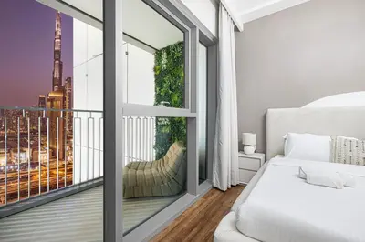 a bedroom with a bed and a large window at Modern Downtown Apartment plus Pool plus Khalifa View in Dubai