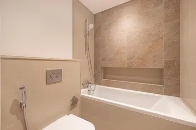 a bathroom with a tub and a toilet and a sink at Modern Downtown Apartment plus Pool plus Khalifa View in Dubai