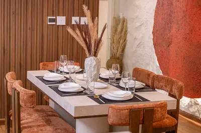 a dining room table with chairs and a vase at Modern Downtown Apartment plus Pool plus Khalifa View in Dubai