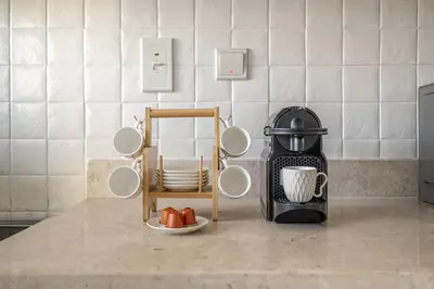 a kitchen counter with cups and plates and a coffee maker at Modern 1BR in Dubai Marina with Balcony Gym & Pool in Dubai