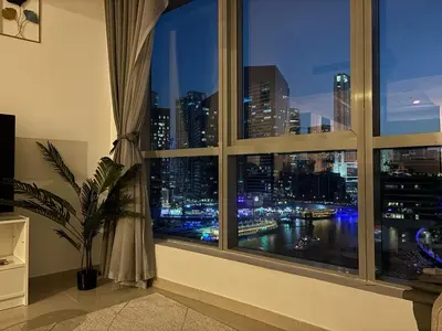 a window with a view of a city at night at 810 Elegant Marina View Apartment Near Tram, Dining & Nightlife, Bay Cental in Dubai