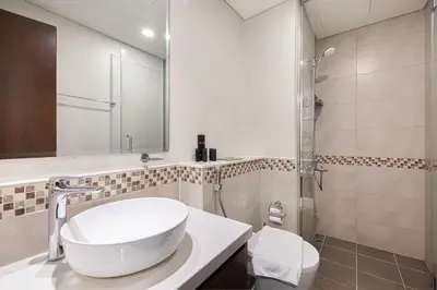 a white bathroom with a sink and a toilet at Stunning Canal View 1BR Apartment Burj Khalifa And Dubai Mall 10 Min Walk Ideal for Up to 4 Guests in Dubai