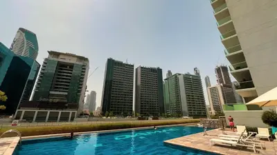 a swimming pool in a city with tall buildings at Stunning Canal View 1BR Apartment Burj Khalifa And Dubai Mall 10 Min Walk Ideal for Up to 4 Guests in Dubai