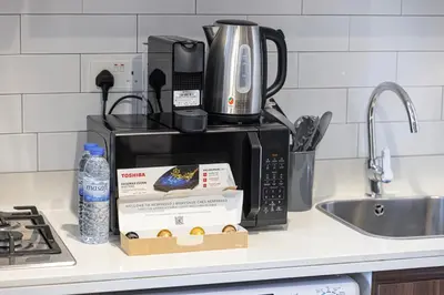 a kitchen counter with a coffee maker on top of a microwave at Stunning Canal View 1BR Apartment Burj Khalifa And Dubai Mall 10 Min Walk Ideal for Up to 4 Guests in Dubai