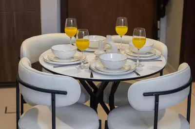 a table with four chairs and glasses of orange juice at Stunning Canal View 1BR Apartment Burj Khalifa And Dubai Mall 10 Min Walk Ideal for Up to 4 Guests in Dubai