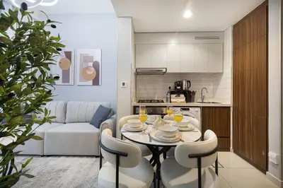 a kitchen and a dining room with a table and chairs at Stunning Canal View 1BR Apartment Burj Khalifa And Dubai Mall 10 Min Walk Ideal for Up to 4 Guests in Dubai