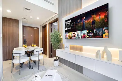 a dining room with a tv on the wall at Stunning Canal View 1BR Apartment Burj Khalifa And Dubai Mall 10 Min Walk Ideal for Up to 4 Guests in Dubai