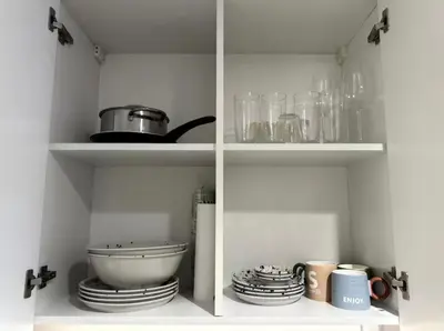 a kitchen with a shelf with a bowl and dishes at Nature luxe estudio Dubai in Dubai