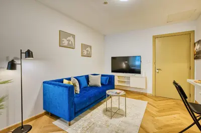 a living room with a blue couch and a tv at PVH - Dubai Gate 1 - Cozy Central Studio in JLT in Dubai