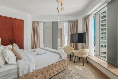 a bedroom with a large bed and a television at Downtown 1BR Full Burj Khalifa & Fountain Views in Dubai
