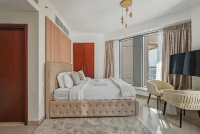 a bedroom with a bed with a television and a table at Downtown 1BR Full Burj Khalifa & Fountain Views in Dubai