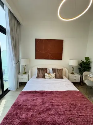 a bedroom with a large bed with a red rug at Posh and Bright New Studio Apartment in Dubai