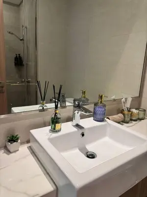 a bathroom with a white sink and a mirror at Posh and Bright New Studio Apartment in Dubai