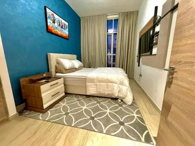 a bedroom with a bed and a dresser and a television at Luxury Apartment Marina in Dubai