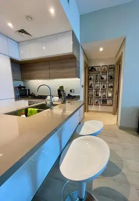 a kitchen with two white stools and a sink at Luxury Apartment Marina in Dubai