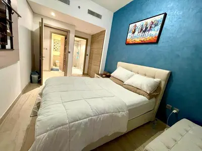 a bedroom with a large bed with a blue wall at Luxury Apartment Marina in Dubai