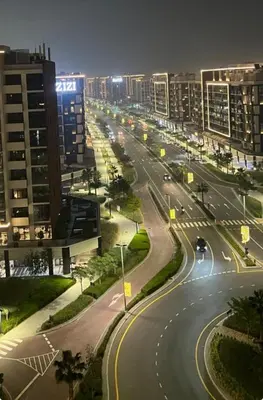 a city street at night with cars on the road at Urban SkyView Apartment Near Downtown Dubai in Dubai