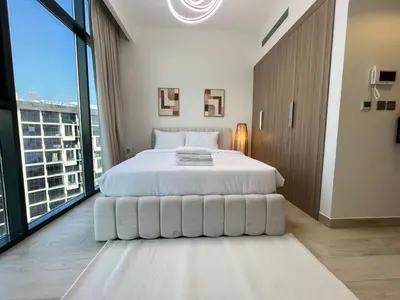 a white bedroom with a large bed and a large window at Urban SkyView Apartment Near Downtown Dubai in Dubai