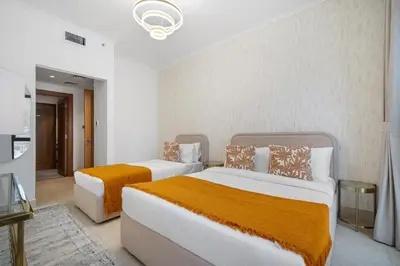 a bedroom with two beds with orange sheets at 5 Minutes Dubai Mall - Burj Khalifa - View pools in Dubai