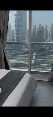 a bedroom with a view of a city from a window at Stunning Modern 1BR Apartment Lake View JLT Lake Terrace in Dubai