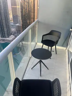 a black chair sitting on top of a balcony at Stunning Modern 1BR Apartment Lake View JLT Lake Terrace in Dubai